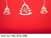 Новогодние и рождественские деревянные игрушки на красном фоне. Стоковое фото, фотограф RF / Фотобанк Лори