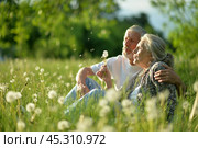 Portrait of senior couple sitting on the grass in the park. Стоковое фото, фотограф Ruslan Huzau / Фотобанк Лори