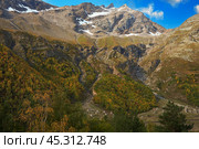 Rocky autumn mountains with melting snow on the top. On the slope avalanche control structure - concrete avalanche cutters. Background image. Стоковое фото, фотограф Роман Дзюбало / Фотобанк Лори