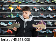 Guy examine view item of autumn comfortable trecking shoes. Стоковое фото, фотограф Яков Филимонов / Фотобанк Лори
