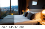 A cozy hotel room with mountain views at dusk showcasing elegant decor and a comfortable atmosphere. Стоковое AI-изображение, AI-художник Сергей Толмачёв / Фотобанк Лори