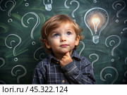 Development and education of children. A thoughtful boy on a dark background with a light bulb and question marks . Brainstorming and the concept of an idea. Стоковое AI-изображение, AI-художник Photojuli / Фотобанк Лори