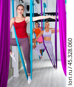 Women making antigravity yoga exercises in stretching twine. Стоковое фото, фотограф Яков Филимонов / Фотобанк Лори