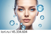 Woman skincare facial treatment concept. Skin care and beauty. Closeup of young woman, glowing face after gel, facial cream. perfect skin, touches her skin, enjoys rejuvenation effect, blue background. Стоковое AI-изображение, AI-художник Павел Муравьев / Фотобанк Лори