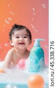 Joyful baby bath time with colorful bubbles and bath toys for adorable moments. Стоковое AI-изображение, AI-художник Sabyna75 / Фотобанк Лори