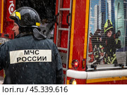 Сотрудник пожарного расчета принимает участие в тушении пожара в центре города Москвы, Россия. Редакционное фото, фотограф Николай Винокуров / Фотобанк Лори