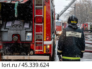 Сотрудник пожарного расчета принимает участие в тушении пожара в центре города Москвы, Россия. Редакционное фото, фотограф Николай Винокуров / Фотобанк Лори