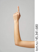 Woman's Hand Pointing Upwards Against a Grey Background. Стоковое фото, фотограф Сергей Толмачёв / Фотобанк Лори