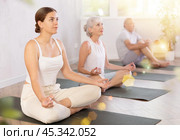 Young lady performs comfortable lotus asana-Padmasana-Siddhasana pose. Стоковое фото, фотограф Яков Филимонов / Фотобанк Лори