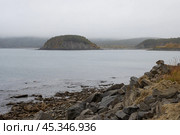 Осенний морской пейзаж. Вид на небольшой остров в морской бухте. Пасмурная погода. Низкие облака. Природа Дальнего Востока России. Остров Вдовушка, бухта Весёлая, Охотское море, Магаданская область, Россия. Стоковое фото, фотограф Андрей Степанов / Фотобанк Лори