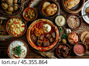 Moroccan tagine with lamb meat, vegetables and couscous on wooden table. Стоковое AI-изображение, AI-художник Иван Рябоконь / Фотобанк Лори
