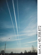 Chemtrail conspiracy theory. Long-lasting condensation trails left in sky by high-flying aircraft are actually chemtrails consisting of chemical or biological agents, sprayed for nefarious purposes. Стоковое AI-изображение, AI-художник Юлия Петровская / Фотобанк Лори