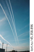 Chemtrail conspiracy theory. Long-lasting condensation trails left in sky by high-flying aircraft are actually chemtrails consisting of chemical or biological agents, sprayed for nefarious purposes. Стоковое AI-изображение, AI-художник Юлия Петровская / Фотобанк Лори