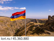 Aerial drone view to flag of Armenia and famous Vahramashen Church of the 11th century, near Amberd fortress in sunny summer day. Cliff with Arkashian River deep in canyon. Aragatsotn region, Armenia. Стоковое фото, фотограф Алексей Ширманов / Фотобанк Лори