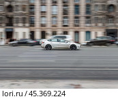 Tesla Model Y all electric car driving down the street. Редакционное фото, фотограф Константин Григорьев / Фотобанк Лори