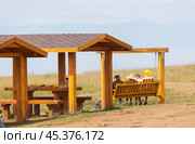 BAIKAL LAKE, OLKHON ISLAND, IRKUTSK REGION, RUSSIA - August 02, 2024: Tourists relax on swings and dine in gazebos after climbing on popular Cape Khoboy on lkhon Island in summer sunny day. Редакционное фото, фотограф Виктория Катьянова / Фотобанк Лори
