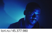 Musician showcasing confidence while posing under striking blue stage lights. Стоковое видео, видеограф Данил Руденко / Фотобанк Лори