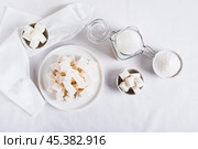 Lump sugar on a plate and granulated sugar in a bowl and jar on the table top view. Стоковое фото, фотограф Елена Руй / Фотобанк Лори