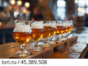 Bartender preparing beer flight in modern bar. Стоковое AI-изображение, AI-художник Иван Рябоконь / Фотобанк Лори