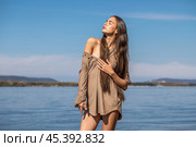 Portrait of a young brunette woman posing in beige tunic. Стоковое фото, фотограф Андрей Аркуша / Фотобанк Лори