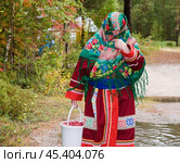 Женщина с ведром осенних ягод возвращается из леса. Ее родовое имение находится в лесу ( недалеко от реки ). Они, коренные жители народов севера - манси, здесь живут годами. Основные продукты - самые, что ни на есть натуральные. Все остальное покупают раз в месяц, в городе. Сообщение с городом круглый год по реке , километров 20-25... (2011 год). Редакционное фото, фотограф Павел Просянов / Фотобанк Лори