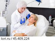 Experienced female cosmetologist performing face contouring injections to woman. Стоковое фото, фотограф Яков Филимонов / Фотобанк Лори