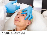 Cosmetologist doing botulotoxin injections for senior woman. Стоковое фото, фотограф Яков Филимонов / Фотобанк Лори
