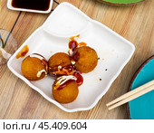 Toasted takoyaki balls containing octopus, seasoned with ketchup and mayonnaise. Стоковое фото, фотограф Яков Филимонов / Фотобанк Лори