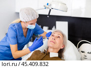 Cosmetologist making injections of botulotoxin in face of mature woman. Стоковое фото, фотограф Яков Филимонов / Фотобанк Лори