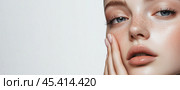 Крупный план молодой женщины с безупречной кожей, французским маникюром на ногтях, позирующей для рекламы косметики на белом фоне. Баннерные обои с copyspace. Стоковое AI-изображение, AI-художник ФотоИнтеллект / Фотобанк Лори
