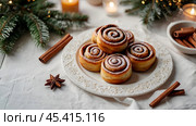 The cinnabons. Close-up of cinnamon buns. Beautiful buns with fresh cinnamon and icing on a wooden table. Fragrant homemade New Year's pastries. Стоковое AI-изображение, AI-художник Photojuli / Фотобанк Лори