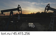 Flying near working oil pumps at sunset. Стоковое видео, видеограф Михаил Коханчиков / Фотобанк Лори