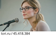 Woman with a Microphone Speaking in Front of an Audience. Стоковое AI-видео, аниматор Юрий Поздников / Фотобанк Лори