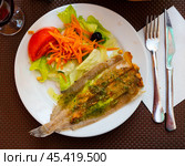 There is plate with fried solea flatfish and salad of fresh veg on wooden table. Стоковое фото, фотограф Яков Филимонов / Фотобанк Лори