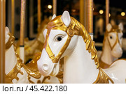 A beautifully designed merrygoround featuring gold and white horses. Стоковое фото, фотограф Аксенова Вера / Фотобанк Лори