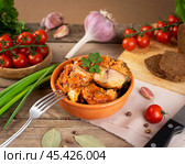 Delicious homemade stewed fish canned fish homemade mackerel served in a rustic setting with fresh vegetables and herbs on a wooden table. Стоковое фото, фотограф Евгения Трушкова / Фотобанк Лори