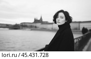 Современная словацкая девушка в огромном пальто у реки в Братиславе. Стоковое AI-изображение, AI-художник ФотоИнтеллект / Фотобанк Лори
