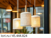 Straw lampshade. Modern pendant lights with light bulb. Contemporary house interior. Hanging ceiling light in a current shared space. Decorative geometric lamp. Suspended straws chandelier loft style. Стоковое AI-изображение, AI-художник Марина Демидюк / Фотобанк Лори