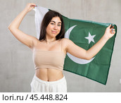 Happy young woman with flag of Pakistan against unicoloured background. Стоковое фото, фотограф Яков Филимонов / Фотобанк Лори