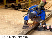 Cutting metal with a hand-held machine with a cutting disc when buying material in a store for building a new house. Стоковое фото, фотограф Акиньшин Владимир / Фотобанк Лори