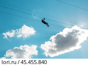 Man on zipline ride high in the sky. Extreme entertainment. Стоковое фото, фотограф Коханова Наталья / Фотобанк Лори