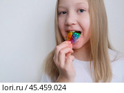 Детская зубная пластина радужного цвета. Ребенок держит в руках ортодонтическую пластинку, чтобы выровнять зубы и расширить челюсть. Стоковое фото, фотограф Терехова Марина / Фотобанк Лори