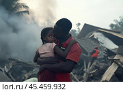 Little girl in the arms of a male rescuer after a missile strike. Стоковое AI-изображение, AI-художник Дмитрий Киселёв / Фотобанк Лори