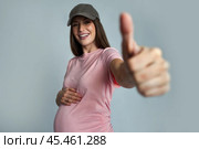 Happy and cheerful young pregnant woman in a baseball cap. Стоковое AI-изображение, AI-художник Дмитрий Киселёв / Фотобанк Лори