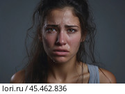 Portrait of a crying caucasian girl with bruised skin on grey studio background. Domestic violence, portrait of abused and hurt young woman crying at home. Sadness and depression concept. Стоковое AI-изображение, AI-художник Sergey Grishin / Фотобанк Лори