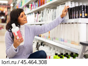 Latin american woman looking for haircare products at cosmetics shop. Стоковое фото, фотограф Яков Филимонов / Фотобанк Лори
