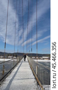 SHAMANKA VILLAGE, SHELEKHOVSKY DISTRIK, IRKUTSK REGION, RUSSIA - November 17, 2024: Vertical video of tourists walk along beautiful cable-stayed pedestrian bridge across the Irkut River on sunny day. Редакционное видео, видеограф Виктория Катьянова / Фотобанк Лори