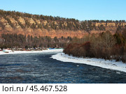 Top view of beautiful Siberian river Irkut in November during freeze-up. Ice floes float on blue water. On shore is Shamanka village near famous Shamansky cliff, called 33 heroes bogatyrs - natural landmark. Стоковое фото, фотограф Виктория Катьянова / Фотобанк Лори