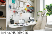 Creative workshop with convenient storage places for all sewing accessories. Wall organizers for threads and tools, neat containers and shelves for fabrics. Sewing content concept. Стоковое фото, фотограф Енваев Андрей / Фотобанк Лори