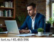 A young businessman is working on a laptop. Стоковое AI-изображение, AI-художник RamA / Фотобанк Лори
